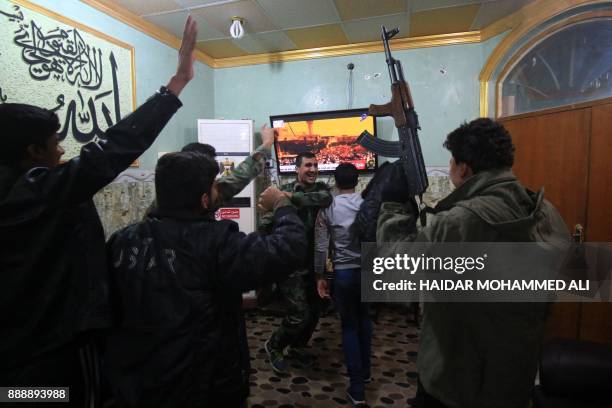 Members of the Hashed al-Shaabi watch the televised statement of Iraqi Prime Minister Haider al-Abadi in the southern city of Basra on December9,...