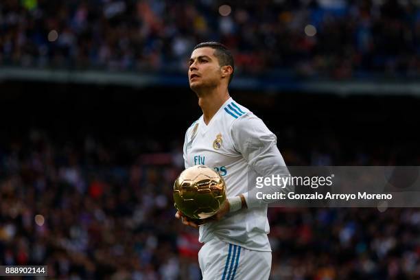 Cristiano Ronaldo of Real Madrid CF offers his fifth Golden Ball trophy to the audience prior to start the La Liga match between Real Madrid CF and...