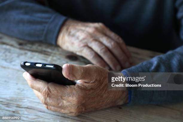 senior man's hands holding a smart phone - old phone fotografías e imágenes de stock