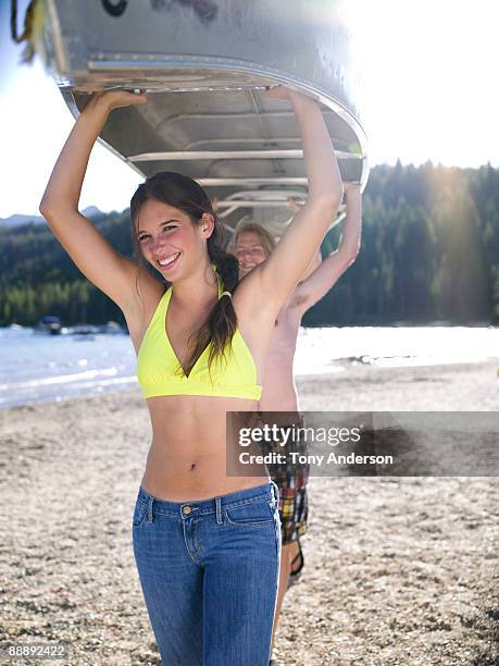 teens carrying canoe away from lake - redfish lake stock pictures, royalty-free photos & images