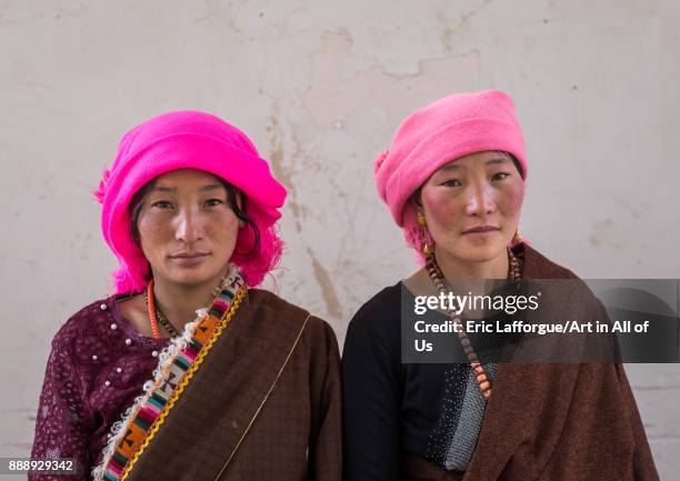 Portrait of tibetan nomads women with a pink headwears, Qinghai province, Tsekhog, China on October 28, 2017 in Tsekhog, China.