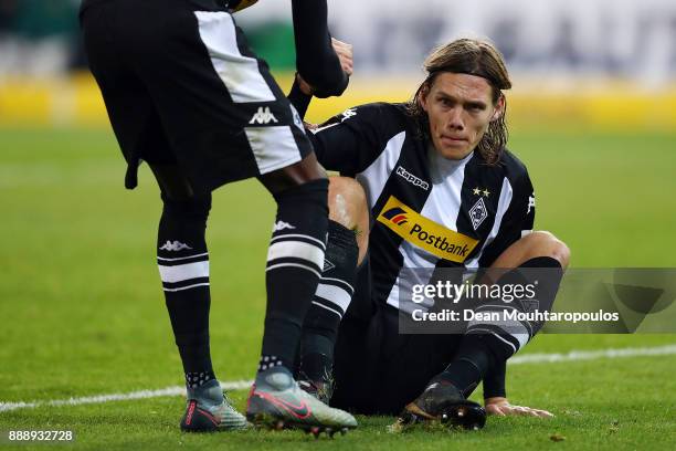 Jannik Vestergaard of Moenchengladbach looks dejected and is helped by a team mate after he scored an own goal to make it 1:1 during the Bundesliga...