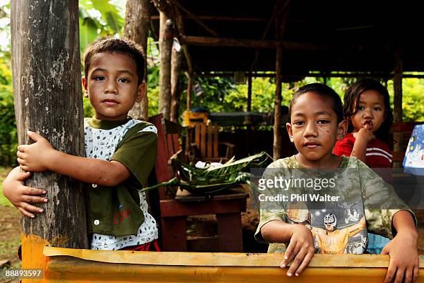 Young village children look on as New Zealand Prime Minister John Key visits a coconut plantation where coconut oil is produced July 7, 2009 in Apia,...