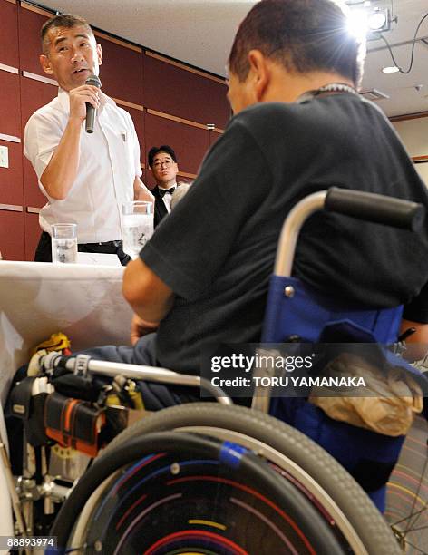 Minamata disease patient Kenji Nagamoto stands beside other patients as he criticizes a bill during a press conference in Tokyo on July 8, 2009. The...