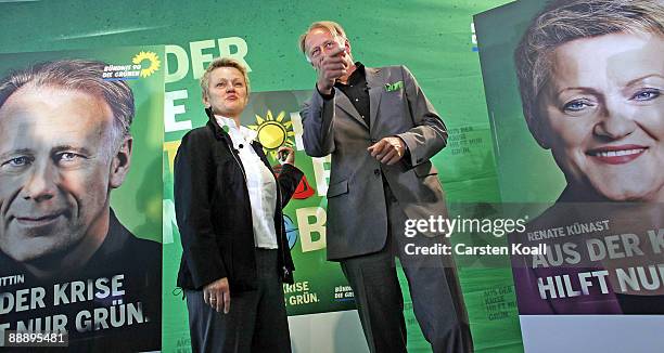 German Greens party lead elections candidates Juergen Trittin and Renate Kuenast pose next to a sign showing the campaign for the next federal...