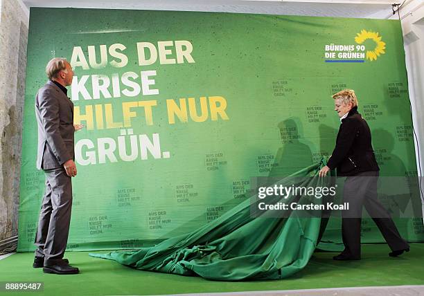 German Greens party lead elections candidates Juergen Trittin and Renate Kuenast pose next to a sign showing the campaign for the next federal...