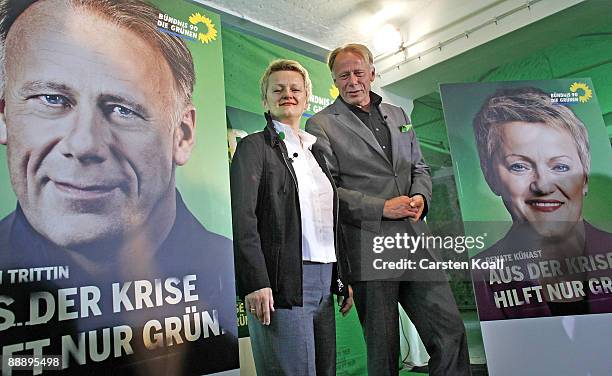 German Greens party lead elections candidates Juergen Trittin and Renate Kuenast pose next to a sign showing the campaign for the next federal...