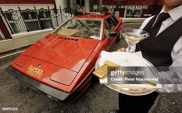 Model holds a limited edition gold plated 'Golden Gun' replica with a Lotus Turbo Esprit car from the 1981 James Bond film For Your Eyes Only is...