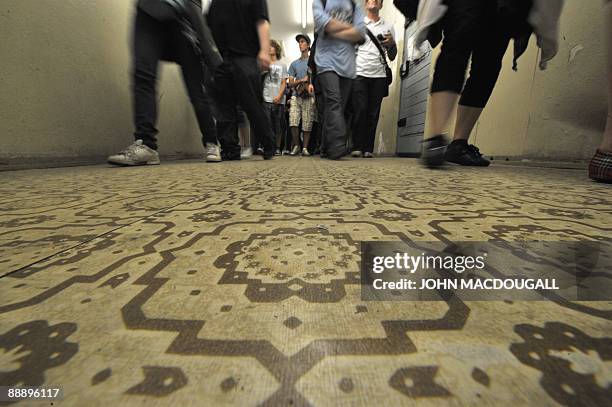 Visitors walk past prison cells in the former prison of the East German, communist-era secret police, known as the Stasi, at Hohenschoenhausen in...