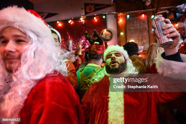 People dressed as Santa Claus participate in the annual bar crawl SantaCon on December 9, 2017 in New York City. The annual bar crawl of festive...