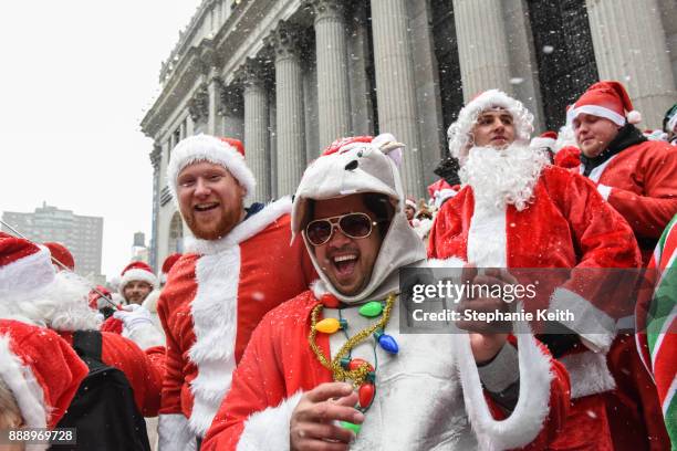 People dressed as Santa Claus participate in the annual bar crawl SantaCon on December 9, 2017 in New York City. The annual bar crawl of festive...