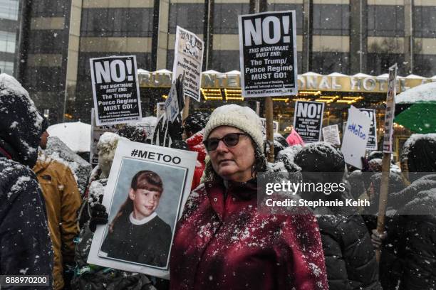 People carry signs addressing the issue of sexual harassment at a #MeToo rally outside of Trump International Hotel on December 9, 2017 in New York...