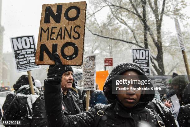 People carry signs addressing the issue of sexual harassment at a #MeToo rally outside of Trump International Hotel on December 9, 2017 in New York...