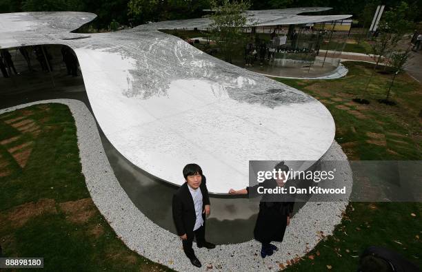 Japanese artists Kazuyo Sejima and Ryue Nishizawa pose for pictures by the new pavillion at the Serpentine Gallery on July 8, 2009 in London,...