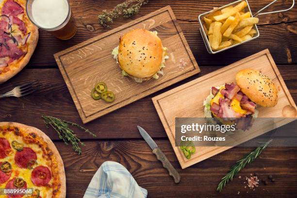 jede menge essen am tisch - bacon cheeseburger stock-fotos und bilder