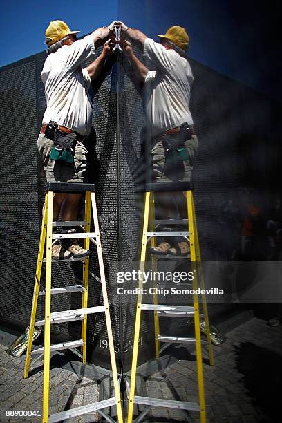 Volunteer Allen McCabe makes a rubbing of the first two names on the Vietname Veterans Memorial, or The Wall, during a ceremony commemorating the...