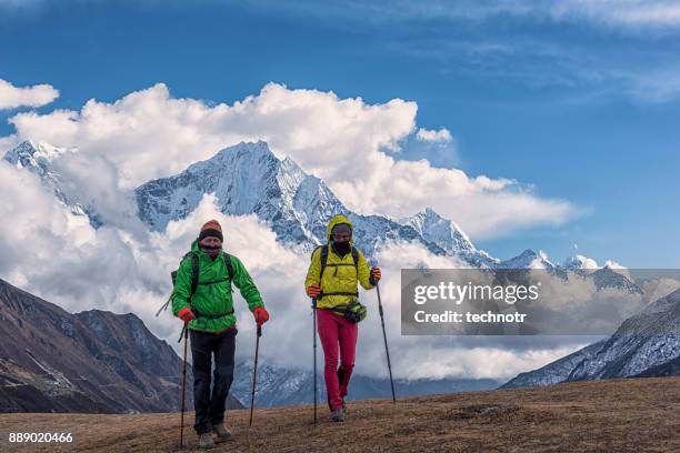 vooraanzicht van jong koppel trekking himalaya, ama dablam op de achtergrond - ama dablam stockfoto's en -beelden