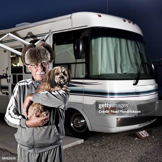 older man holding dog in front of rv - moustaches animales fotografías e imágenes de stock
