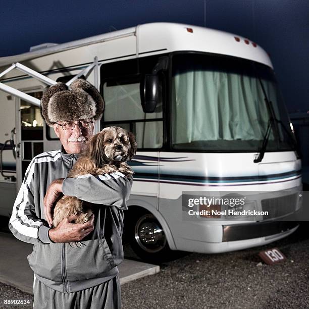 older man holding dog in front of rv - bontmuts stockfoto's en -beelden