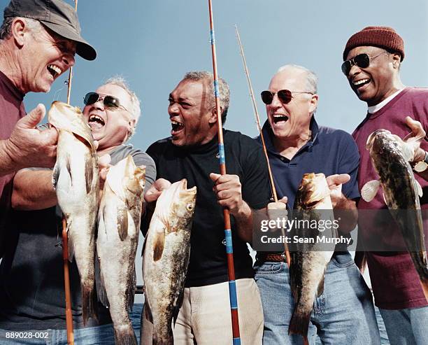 five mature men holding catch (calico bass) on deck of boat - mature men group stock pictures, royalty-free photos & images