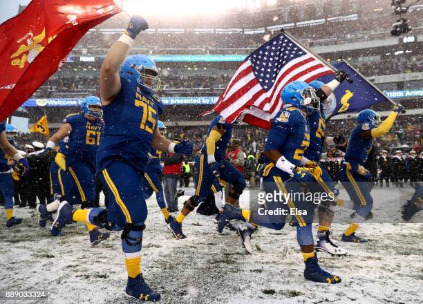 The Navy Midshipmen run out on the field before the game against the Army Black Knights on December 9, 2017 at Lincoln Financial Field in...