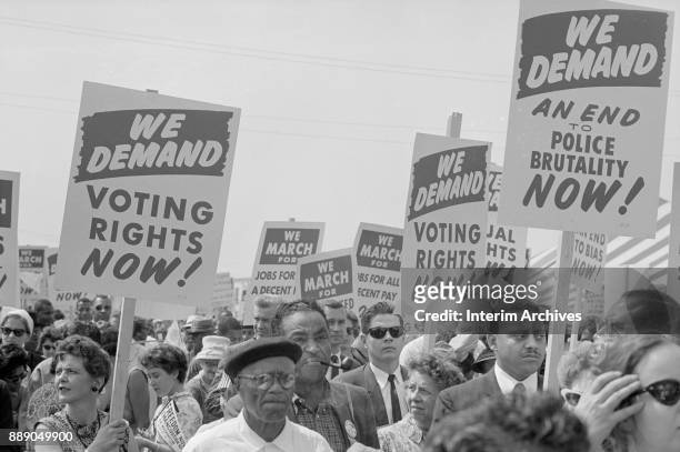 Demonstrators hold up signs as they participate in the March on Washington for Jobs and Freedom, Washington DC, August 28, 1963. Among the visible...