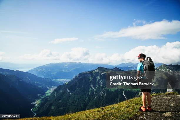 teenage boy on hike in swiss alp taking in view from mannlichen of interlaken switzerland - mannlichen stock pictures, royalty-free photos & images