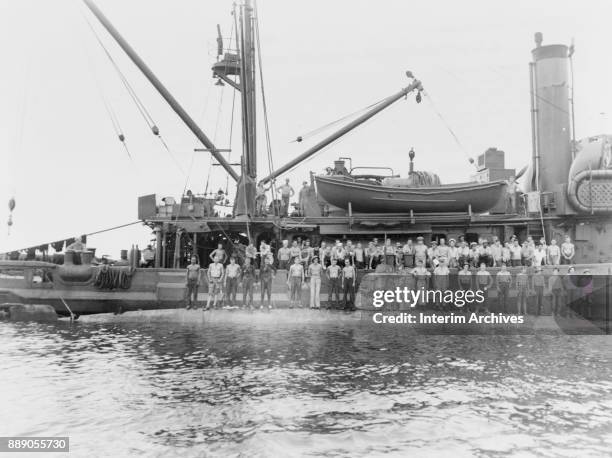 Crew portrait of the USS Ortolan as they stand on the hull of a raised Japanese midget submarine off the island of Guadalcanal, 1943.