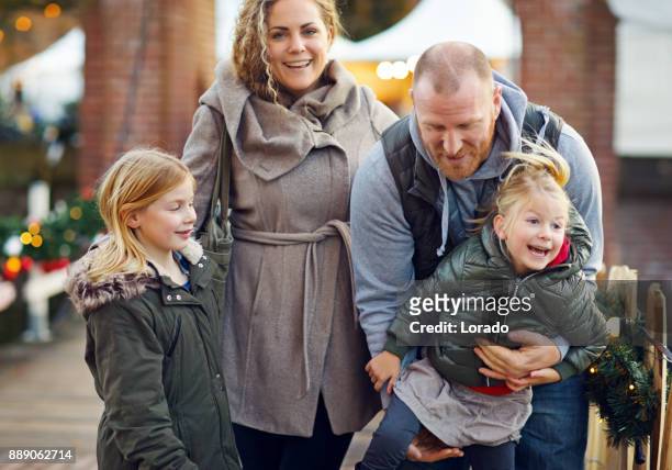 twee mooie blonde zusters met blonde moeder en vader van de roodharige op winter kerstmarkt - utrecht stockfoto's en -beelden