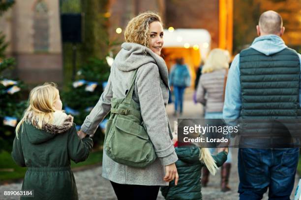 twee mooie blonde zusters met blonde moeder en vader van de roodharige op winter kerstmarkt - utrecht stockfoto's en -beelden