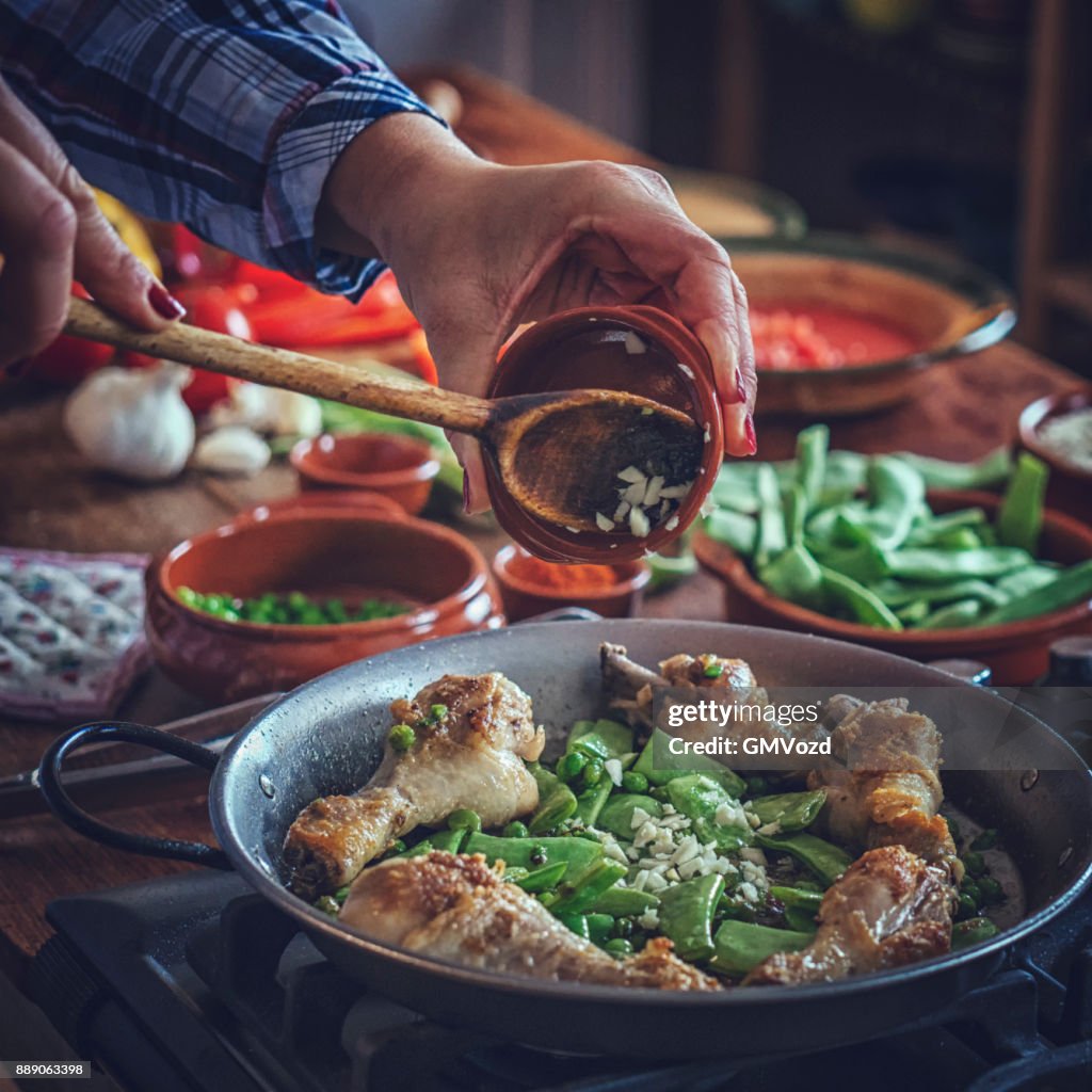 Voorbereiding van de Paella van kip met groene bonen, erwten en Paprika