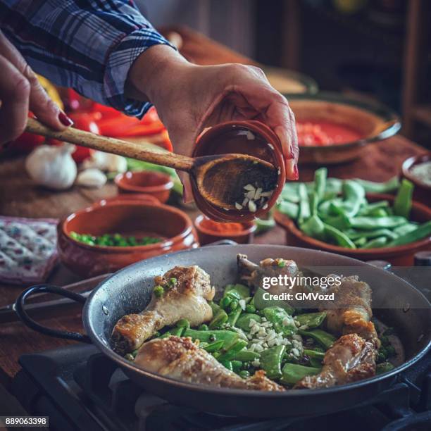 preparing chicken paella with green beans, peas and paprika - drumstick stock pictures, royalty-free photos & images