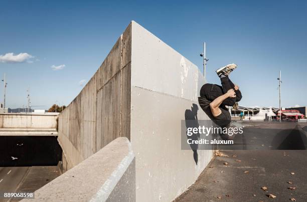 hombre practicar parkour en la ciudad - backflipping fotografías e imágenes de stock