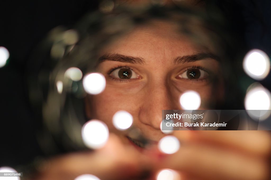Woman wrapped in christmas lights