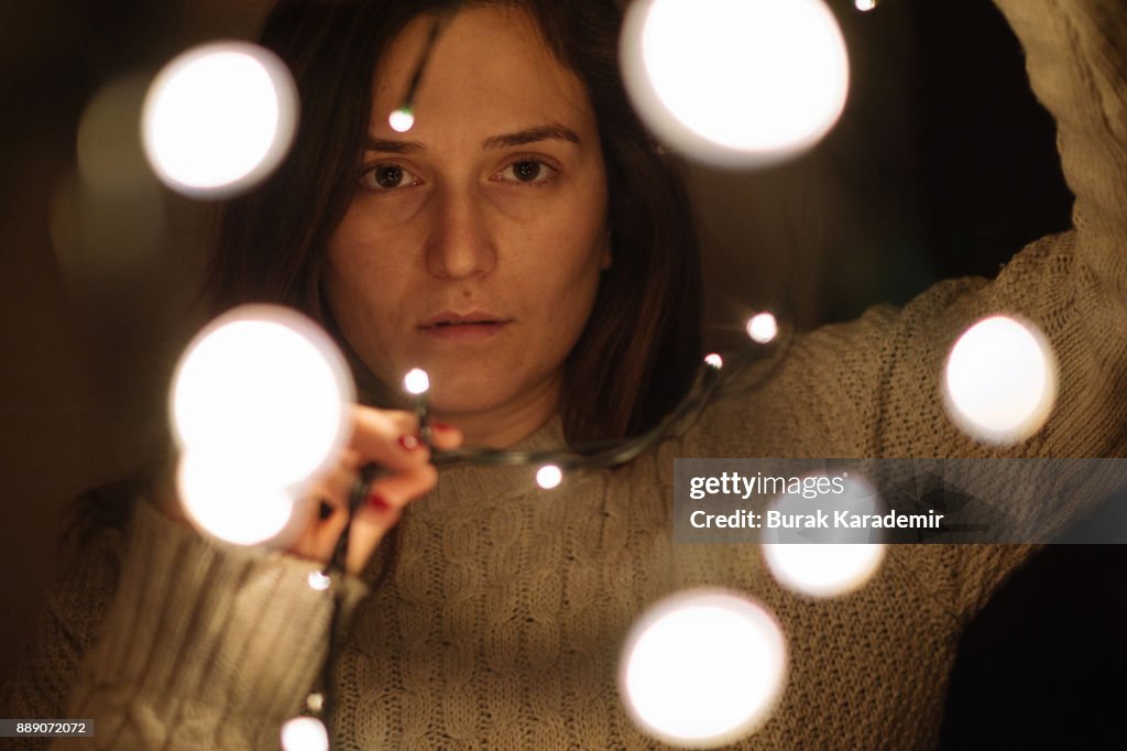 Woman wrapped in christmas lights