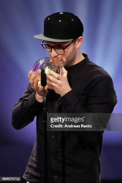 Mark Forster kisses his award for best single on stage during the 1Live Krone radio award at Jahrhunderthalle on December 07, 2017 in Bochum, Germany.