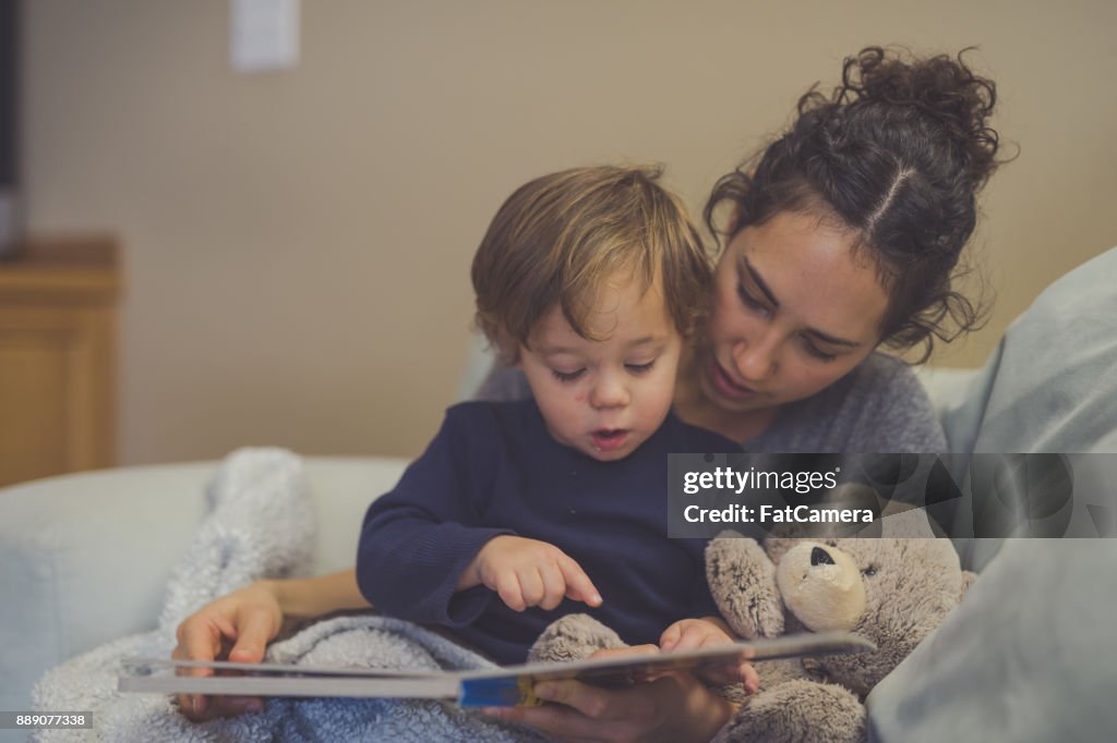 Mom and Son Reading Book Together in Living Room