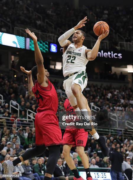 Miles Bridges of the Michigan State Spartans shoots over Christian Musoko of the Southern Utah Thunderbirds at Breslin Center on December 9, 2017 in...