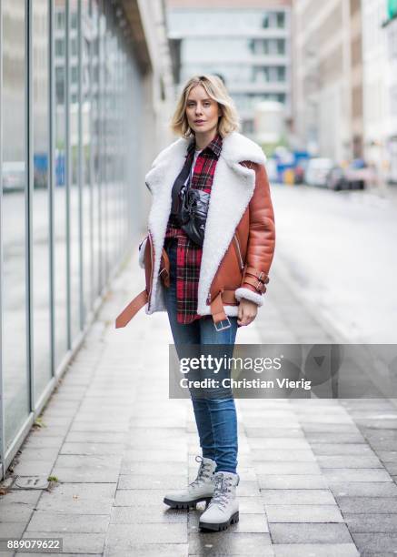 Lisa Hahnbueck wearing brown Acne Studios pistol leather jacket with inner lining, red checked Saint Laurent button shirt, blue J Brand jeans, white...