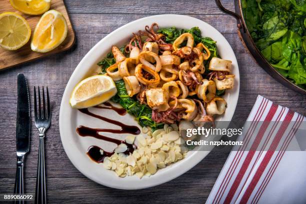 fried calamari with spinach / food photography (click for more) - cook battered fish stock pictures, royalty-free photos & images