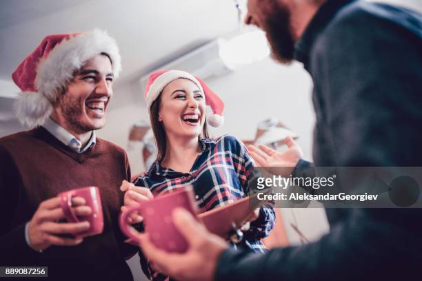 smiling group of friends drink eggnog and celebrate the holidays together - college dorm party stock pictures, royalty-free photos & images