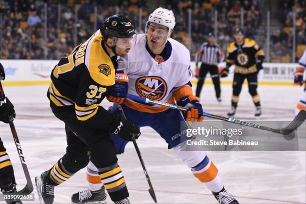 Anders Lee of the New York Islanders skates against Patrice Bergeron of the Boston Bruins at the TD Garden on December 9, 2017 in Boston,...