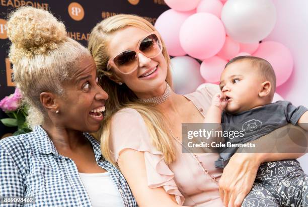 Paris Hilton poses for a photo holding a fans baby during a promotion visit to Australia to launch her 23rd fragrance, Rosé Rush on November 30, 2017...