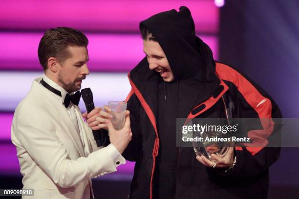 Klaas Heufer-Umlauf takes RIN's cup after he wins the award for best album on stage during the 1Live Krone radio award at Jahrhunderthalle on...