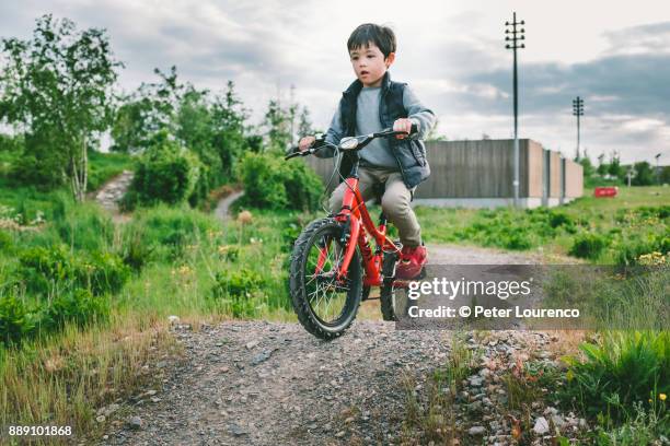 a young boy riding his bike on dirt track - bumpy stock pictures, royalty-free photos & images