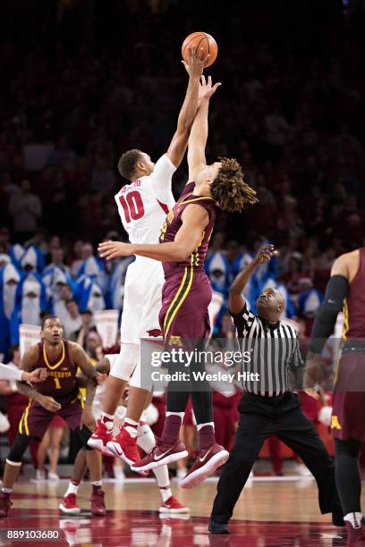 Daniel Gafford of the Arkansas Razorbacks gets the tip off over Reggie Lynch of the Minnesota Golden Gophers at Bud Walton Arena on December 9, 2017...