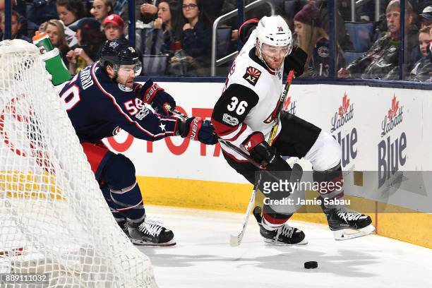 David Savard of the Columbus Blue Jackets stick checks Christian Fischer of the Arizona Coyotes while chasing after the puck during the second period...