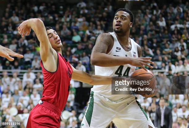 Nick Ward of the Michigan State Spartans handles the ball defended by Dre Marin of the Southern Utah Thunderbirds at Breslin Center on December 9,...