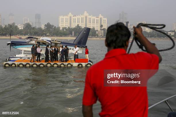 Crew member tends to a rope as attendees stand in front of a Quest Aircraft Co. Amphibious Kodiak plane, operated by SpiceJet, during a demonstration...