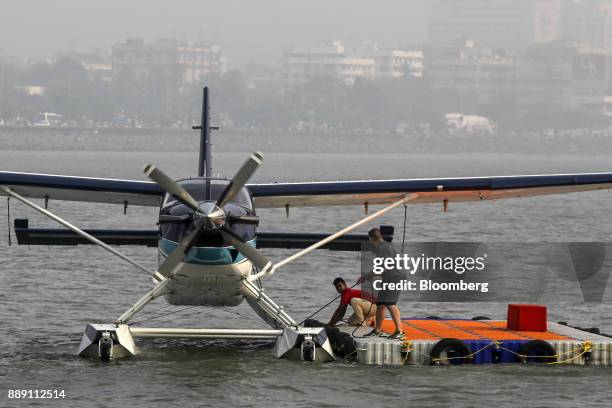 Workers secure a Quest Aircraft Co. Amphibious Kodiak plane, operated by SpiceJet Ltd., after landing on water during a demonstration flight event in...